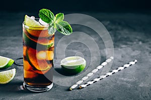 Rum and Cola Cuba Libre ice cold drink cocktail with lime and mint