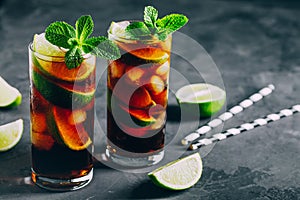 Rum and Cola Cuba Libre ice cold drink cocktail with lime and mint