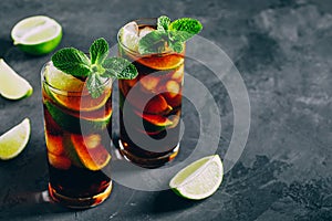 Rum and Cola Cuba Libre ice cold drink cocktail with lime and mint