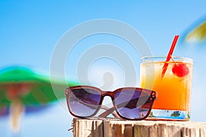 Rum punch cocktail and sunglasses at tropical