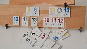 Rummy game formations arranged on the board in selective focus. Wooden board with sets of numbers