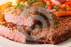 Rump steak in breadcrumbs and garnished with vegetables macro ho