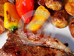 Rump steak red and yellow baby peppers and baby potatoes
