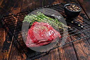 Rump steak with spices, raw beef meat. Wooden background. Top view