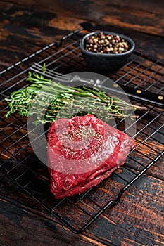 Rump steak with spices, raw beef meat. Wooden background. Top view