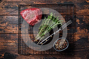 Rump steak with spices, raw beef meat. Wooden background. Top view