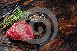 Rump steak with spices, raw beef meat. Wooden background. Top view. Copy space