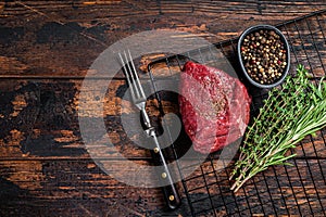 Rump steak with spices, raw beef meat. Wooden background. Top view. Copy space