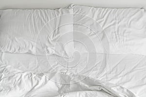 rumpled bed with white messy pillow decoration in bedroom