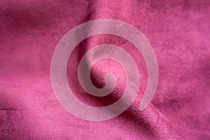 Rumpled cerise-colored faux suede fabric from above