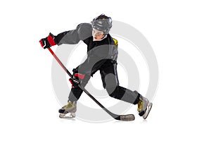 On the run. Child, hockey player with the stick on ice court and white background.