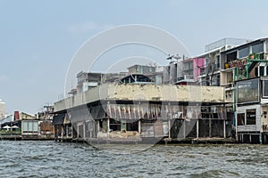 Run-down warehouse and dwellings along Chao Phraya River, Bangkok Thailand