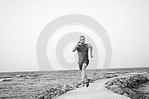 Run fast or be last. Running man on beach. Runner training outdoors. Fit male sport fitness exercising in summer