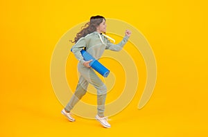 Run and jump. Teenage girl dressed in sports uniform, posing in the studio. Child in a posh stylish sports suit in a