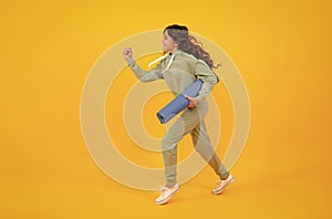 Run and jump. Teenage girl dressed in sports uniform, posing in the studio. Child in a posh stylish sports suit in a