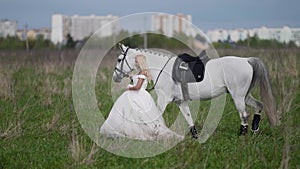 runaway bride and horse are walking on field, romantic woman and white equine