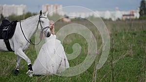 runaway bride is leading horse by bridle on field, romantic and freedom