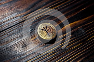 Rune Algiz Elhaz carved from wood on a wooden background photo