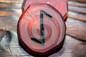 Rune Eihwaz Eihaz red color carved from wood on a wooden background