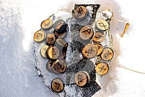 Runes carved from wood on the snow - Elder Futhark