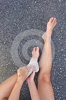 Runner with ankle injury holds her foot