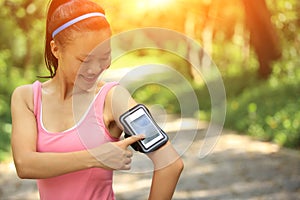 Runner athlete listening to music in headphones from smart phone mp3 player