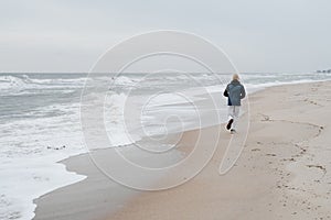 Runner athlete man running in autumn fall by the water jogging by water