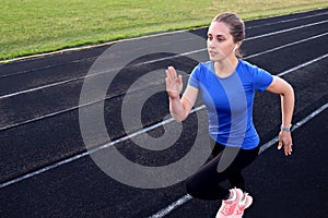 Runner athlete running on athletic track training her cardio in stadium. Jogging at fast pace for competition