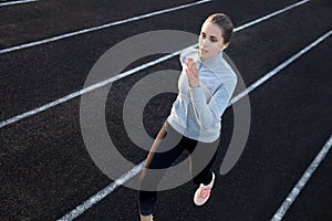 Runner athlete running on athletic track training her cardio in stadium. Jogging at fast pace for competition