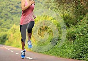 Runner athlete running on forest trail.