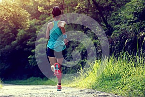 Runner athlete running on forest trail photo