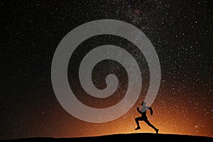 Runner athlete running on the hill with beautiful starry night