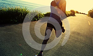 Runner athlete running at seaside road