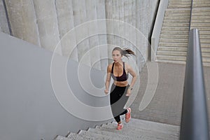 Runner athlete running on stairs. Woman fitness is jogging oudoors