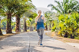 Runner athlete running at tropical park. woman fitness sunrise jogging workout wellness concept