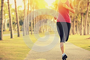 Runner athlete running at tropical park. woman fitness sunrise jogging workout