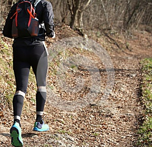 Runner from behind during racing on the mountain trail in winter