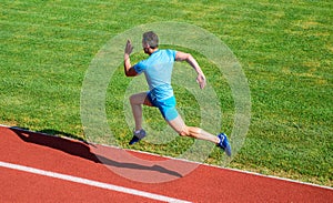 Runner captured in midair. Short distance running challenge. Boost speed. Athlete run track grass background. Run into