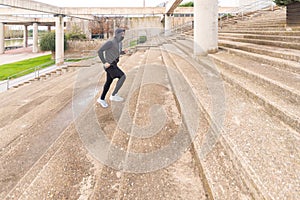 Runner climbing the stairs. Dressed in sportswear wearing a mask.