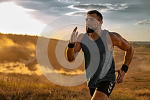 Runner concept. Athletic man running trail on sunset wearing in the sportswear. Fitness and sport motivation. Athlete