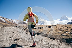 Runner cross country running in winter mountains