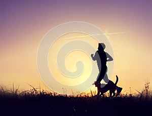 Runner with dog silhouettes at the sunset