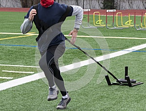Runner dragging a sled with weight for resistance training