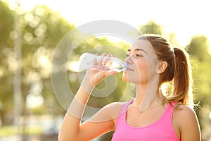 Runner drinking water from a bottle in a park