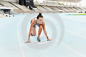 Runner, exercise and start for female athlete in set, track and fitness for sports competition. Race, kneel position and