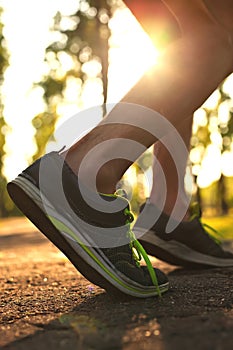 Runner feet running on road.