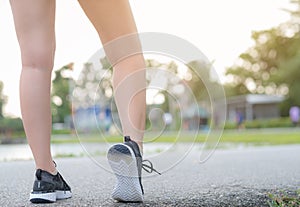 Runner feet running on road closeup leg on shoe. woman fitness sunrise jog workout wellness concept