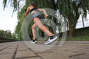 Runner feet running on road closeup on shoe, outdoor at sunset or sunrise