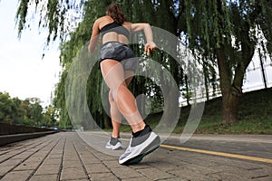 Runner feet running on road closeup on shoe, outdoor at sunset or sunrise