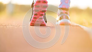 Runner feet running on road closeup on shoe. woman fitness sunri